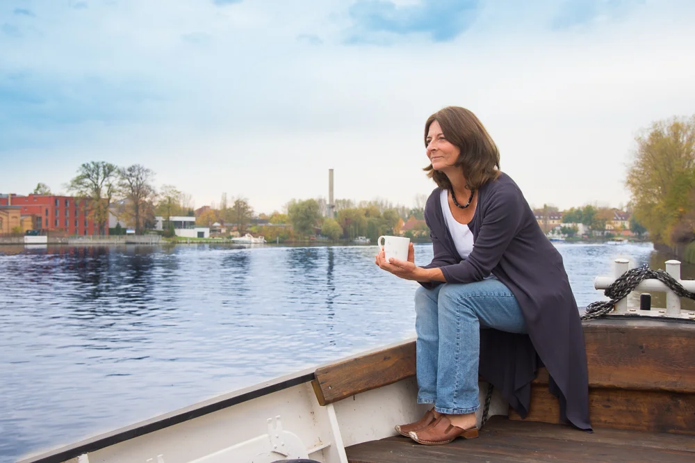 Kerstin Hack mit Kaffeetasse an Bord ihres Schiffs auf der Spree